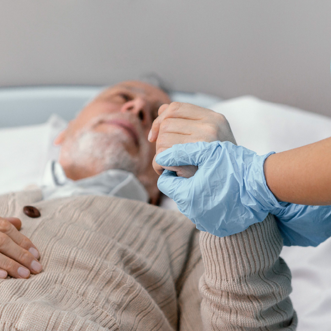 Enfermera con guantes acompañando a un paciente durante su recuperación post-operatoria