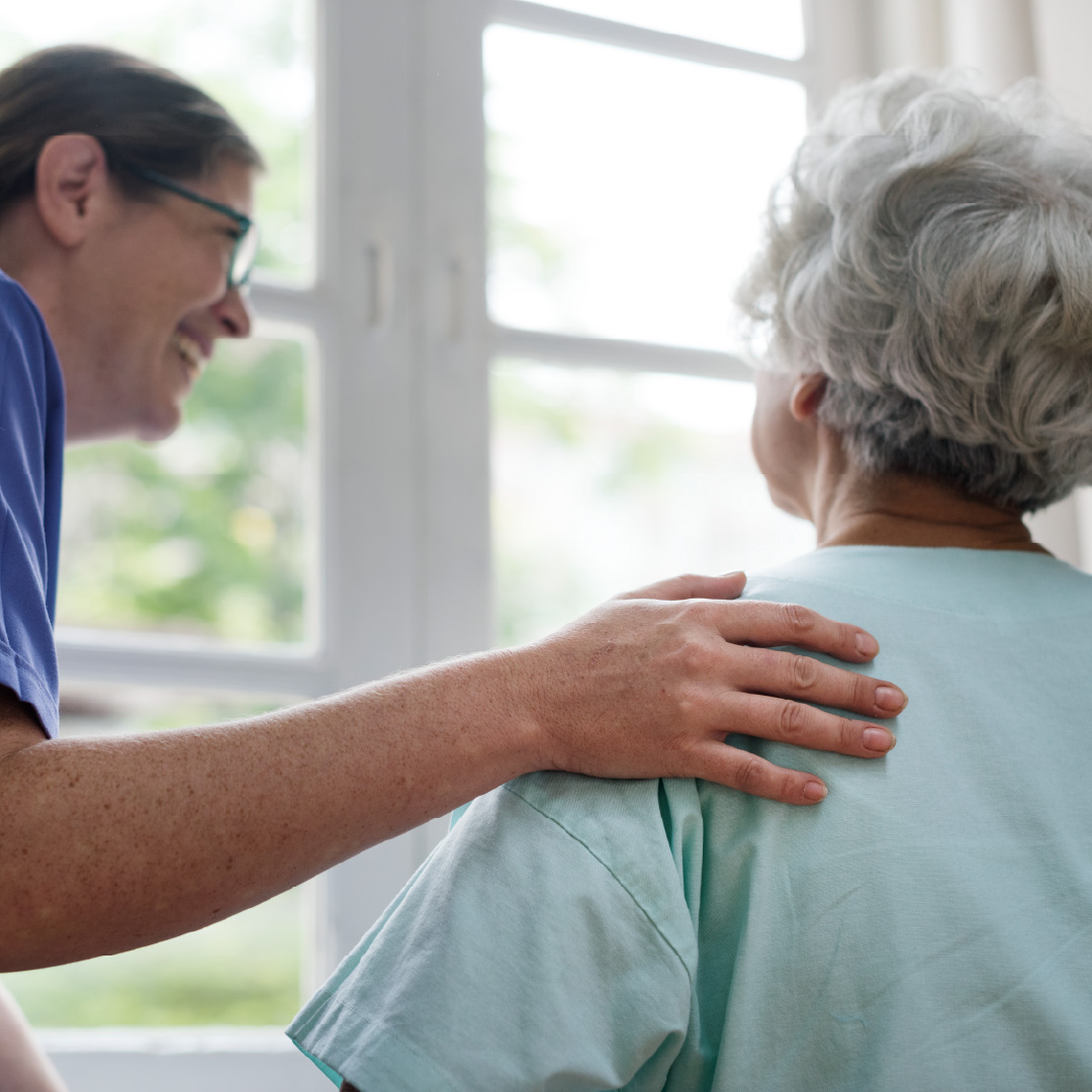 Profesional de geriatría acompañando con calidez a una paciente adulta mayor