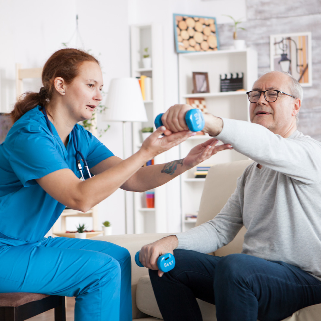Kinesióloga asistiendo a un paciente en una sesión de rehabilitación domiciliaria